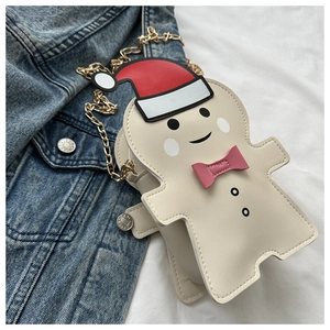 Macro shot of gingerbread man shaped bag with gold chain strap on denim fabric