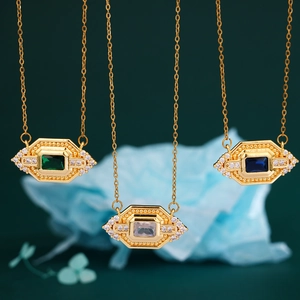 Vintage gold necklaces with colorful square crystals and diamonds on green background