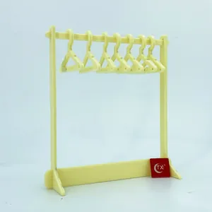 Mini acrylic clothes hanger jewelry rack with eight earring holders in pale yellow