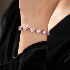 Detail of pink round zircon bead bracelet with silver-tone setting on model's wrist