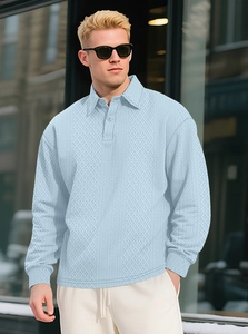 Detailed close-up of light blue men's polo shirt featuring a textured diamond knit pattern