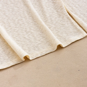Gros plan sur la texture du tricot côtelé doux blanc crème pour haut court à manches longues