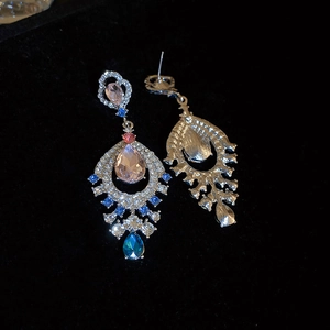 Detail of vintage palace drop earrings with pink pear-shaped crystal and blue rhinestones
