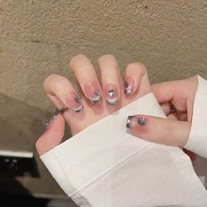 Unghie finte French con effetto cat eye rosa e ciondoli a cuore in metallo 3D argento