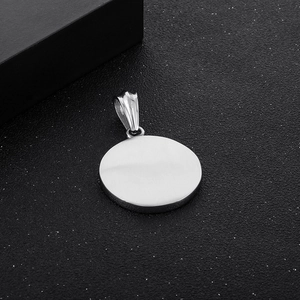 Detailed view of a silver hammered texture round pendant on a dark textured surface