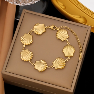 Detail view of gold shell bracelet with S.STEEL engraving on a jewelry box