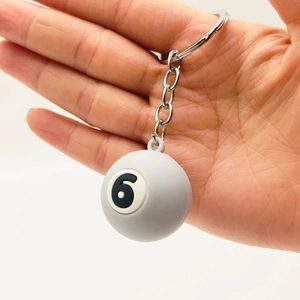 Close-up of gray billiard ball keychain number 6 with metallic chain on white background