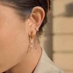 Detail of 18K gold-plated teardrop tassel earrings with crystal stone on a model