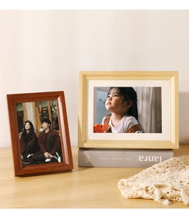 Detailed view of minimalist wooden picture frames in walnut and oak finishes