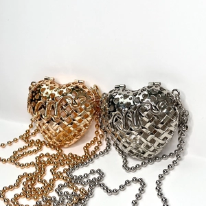 Detail showing gold and silver heart-shaped metal woven evening bags with ball chains