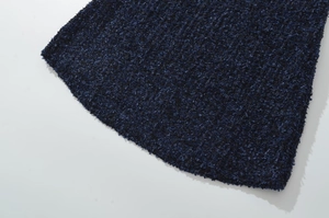 Dettaglio macro della trama in maglia boucle blu scuro per cardigan invernale chic