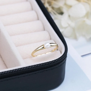 Dettaglio di un anello vintage con perla in argento 925 in una scatola regalo con fiori
