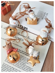 Close-up of vintage resin Christmas ornaments on golden bells with silk ribbons