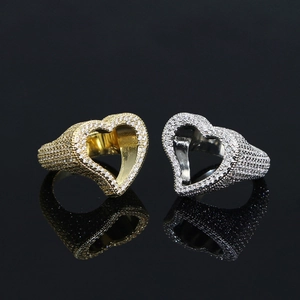 Macro detail of gold and silver hollow heart rings with paved zircon stones on black background
