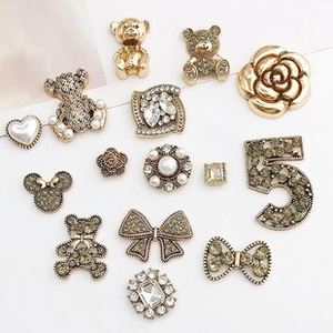Detailed collection of gold metal charms featuring camellias and crystal accents
