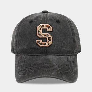 Close-up detail of a vintage black cotton baseball cap with a leopard print S patch