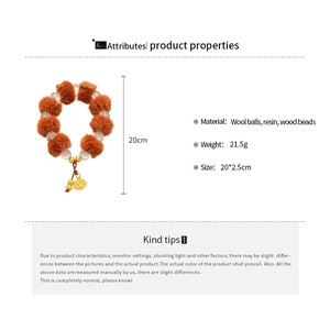 Détail du bracelet en perles avec boules de laine orange et pendentif lotus doré