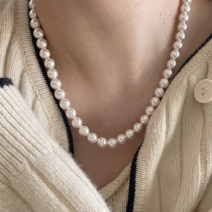 Minimalist 925 sterling silver pearl necklace worn over a beige knit sweater for women