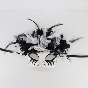 Detail of Day of the Dead mask featuring intricate black feathers, lace, and floral accents