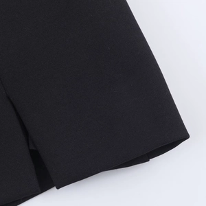Vue détaillée de la couture précise et de l'ourlet du tissu de la mini robe noire en gros plan