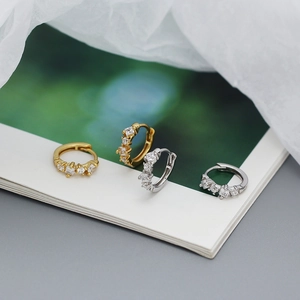 Detailed view of 925 silver hoop earrings with glittering cubic zirconia on soft white silk