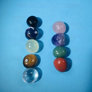 Flat lay of 9 kinds of natural crystal stones with names on blue background