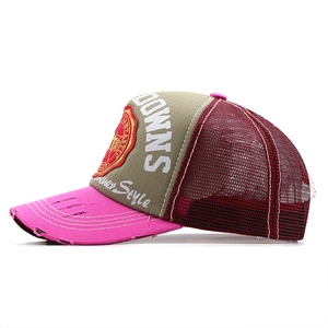 Detail of distressed pink brim and embroidered DOWNS patch on retro trucker hat