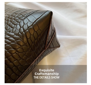 Close-up of high-quality stitching on dark brown crocodile pattern leather tote bag