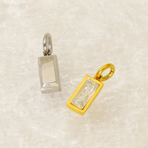 Detailed shot of gold and silver rectangle pendants with birthstones on textured cloth