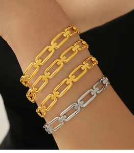 Détail de bracelets à maillons dorés et argentés portés au poignet pour un look chic