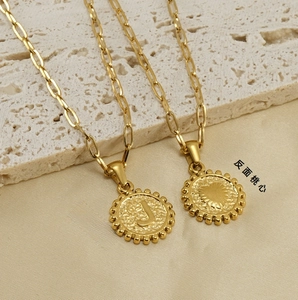 Detail of 18K gold paperclip necklace showing a raised letter J and heart on the pendant