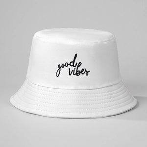 Close-up of black 'good vibes' embroidery on white canvas bucket hat with stitching