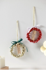 Detail of handmade Christmas bell wreaths in red and gold with festive ribbons and tags