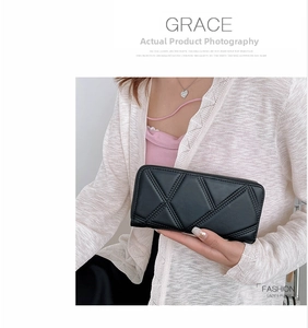 Detail of black PU leather quilted wallet featuring a golden zipper and geometric pattern