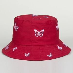 Close-up of white butterfly embroidery on red cotton twill bucket hat texture