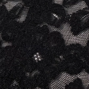 Gros plan détaillé sur la dentelle florale noire avec une texture de maille délicate