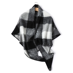 Detail view of monochrome plaid cashmere-like scarf hanging on a wooden hanger