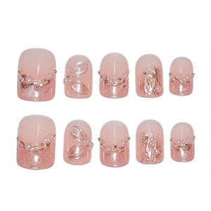 Faux ongles French œil de chat rose avec perles, chaîne de diamants et rubans dorés