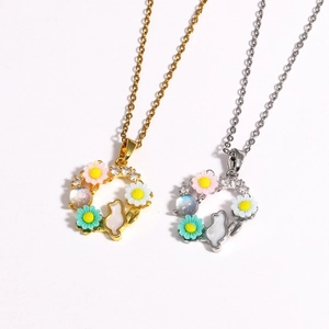 Détail des pendentifs couronne florale avec lapin en or et argent et marguerites émaillées