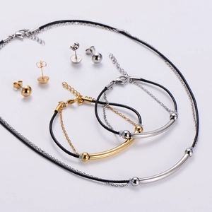 Detail view of two-tone gold and silver jewelry set with woven ropes and metallic spheres