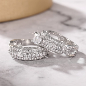 Macro shot of silver wedding ring set with four-prong round zircon and pavé band details