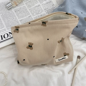 Detail of cute bear corduroy makeup bag with embroidery on aesthetic fabric surface