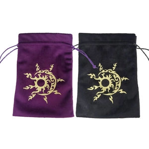 Detail of purple and black velvet drawstring bags with gold sun and moon mystical patterns