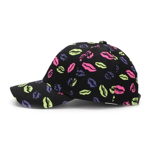 Detail of neon lip pattern on black cotton twill baseball cap with curved brim