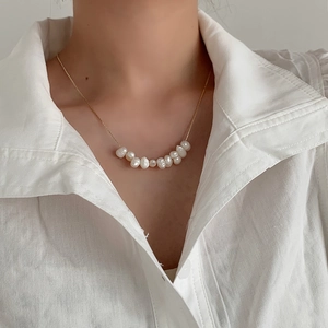 Elegant natural freshwater pearl necklace with gold chain worn on a white shirt