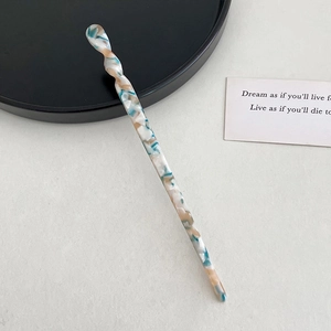 Detailed macro view of spiral acetate hair stick with elegant blue marble pattern