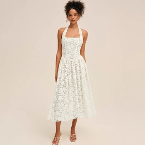 Détail de la robe en dentelle blanche avec licou, taille ajustée et silhouette trapèze