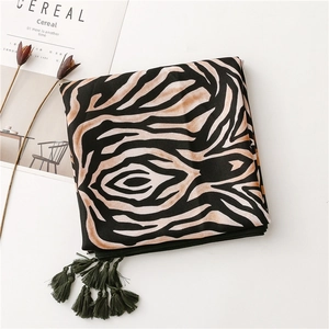 Close-up of zebra pattern scarf with dark green tassels and soft fabric texture