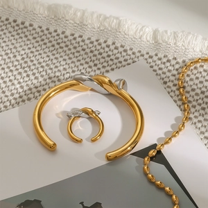 Détail d'un ensemble bracelet et bague en acier inoxydable torsadé bicolore or et argent