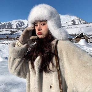 Close-up of white plush trapper hat texture with snow mountain scenery backdrop
